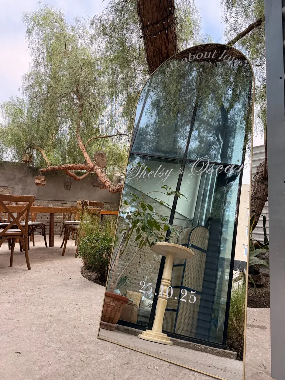 Espejo de bienvenida personalizado junto a un sauce en un jardín