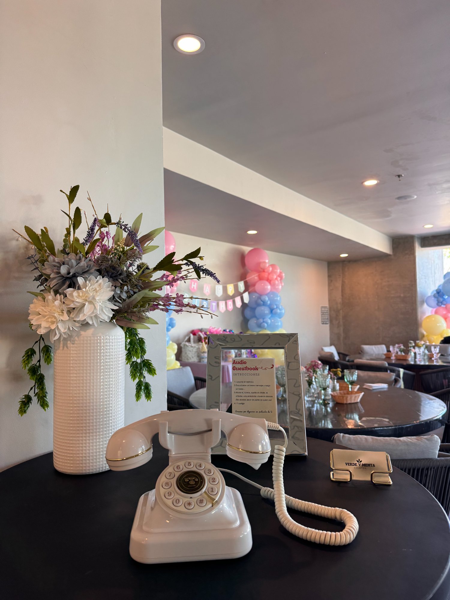 Audio Guest Book de Verde y Menta Eventos — teléfono retro blanco en fiesta con globos de colores